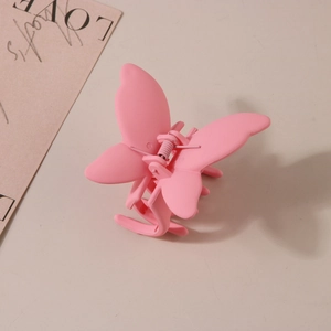 Détail d'une pince à cheveux papillon rose avec finition mate et ailes à double couche