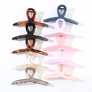 Detailed overhead view of nine large 13cm resin hair claw clips in various elegant colors