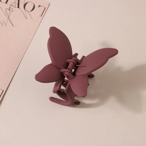 Gros plan d'une pince à cheveux papillon mauve mat au design minimaliste et élégant
