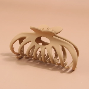 Detail shot of heart-shaped handle on large matte light brown shark hair claw clip
