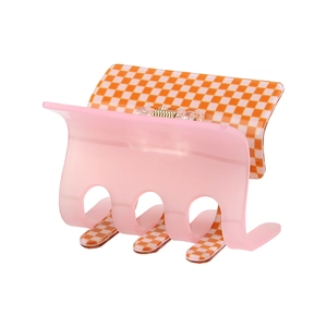 Detail of checkered pink hair claw clip showing high-quality metal spring and glossy finish