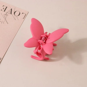 Vue détaillée d'une pince à cheveux papillon avec finition rose mat et mécanisme à ressort