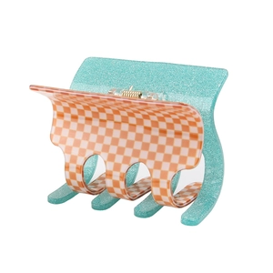 Close-up of checkered claw clip with blue glitter finish and metal spring detail