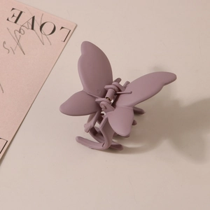 Détail de la pince à cheveux papillon violet mat avec mécanisme à ressort métallique