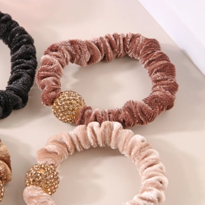 Dettaglio di elastici in velluto con una scintillante perla dorata con cristalli