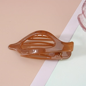 Vue détaillée d'une grande pince à cheveux ambre en acrylique au design évidé élégant