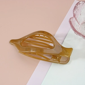 Détail d'une grande pince à cheveux ambre en acrylique translucide avec ressort en métal