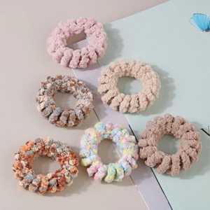 Détail de six chouchous spirales en peluche douce aux tons pastel et couleurs mélangées