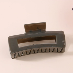 Detail view of large olive green rectangular hair claw clip with cutout design