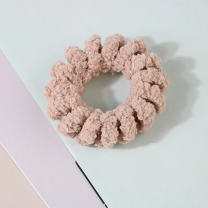 Gros plan sur un élastique à cheveux spirale en peluche rose avec texture douce