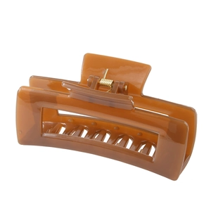 Detail view of caramel brown rectangular hair claw with glossy finish and metal spring