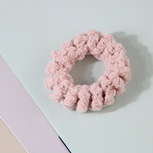 Détail d'un élastique spirale en peluche rose avec texture chenille douce et fils brillants