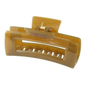 Macro detail of amber-green rectangular hair claw clip with golden metal spring
