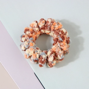 Gros plan de l'élastique cheveux spirale en peluche avec texture tissée multicolore