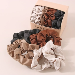 Set of satin scrunchies in earthy tones with a minimalist fashion packaging box