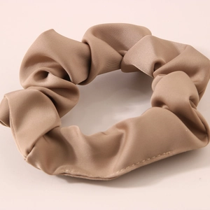 Close-up of champagne satin scrunchie showing smooth silk texture and fine stitching