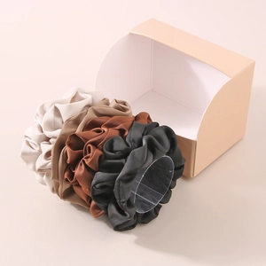 Set of 4 large milk silk scrunchies in neutral earth tones on a transparent stand