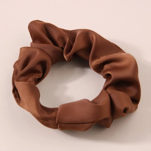 Detailed close-up of glossy coffee milk silk scrunchie showing fabric texture