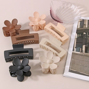 Close-up of matte flower and rectangular hair claws in earth tones on a magazine