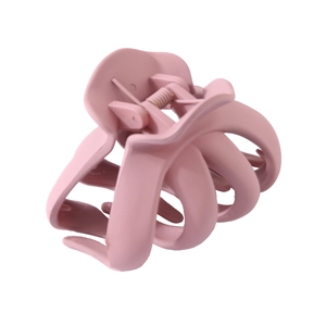 Détail d'une pince à cheveux rose mat avec design à 8 griffes et ressort robuste