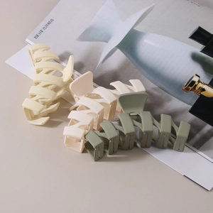 Three-piece large matte hair claw clips in pastel yellow, cream, and bean green