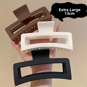 Detail view of 13cm matte hollow hair claw clip showing size scale held in hand