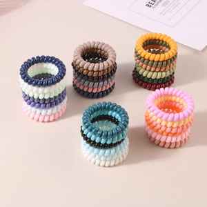 Macro shot of colorful spiral telephone wire hair ties in various Morandi tone sets