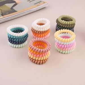 Close-up of assorted spiral hair ties in vibrant colors with a lifestyle magazine background