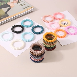 Colorful spiral telephone cord hair ties stacked neatly on a stylish fashion magazine