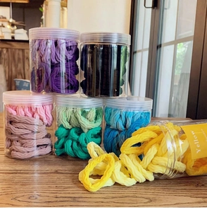 Macro shot of colorful seamless spiral hair ties scattered on a wooden table with packaging