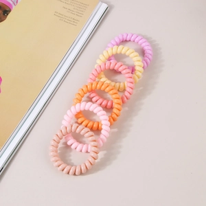 Set de seis gomas de pelo en espiral de colores para mujer sobre fondo de revista suave