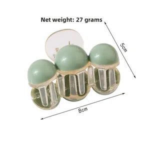 Detail view of green and transparent hair claw clip showing 8cm length and 5cm height
