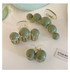 Detailed set of three greyish green spherical resin hair claws in various sizes
