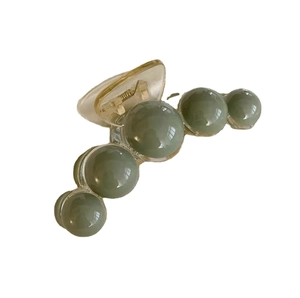 Elegant green pearl hair claw clip with transparent resin base and gold spring