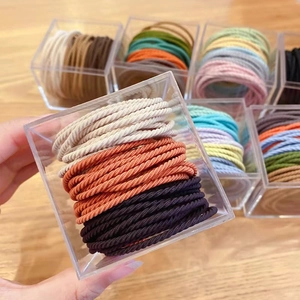 Elastic ribbed hair ties set in acrylic box featuring durable multi-color braided bands