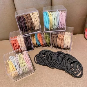 Detail of high-elasticity braided hair ties in various colors and clear storage box