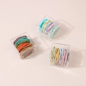 Detailed macro view of colorful elastic hair ties set in three transparent plastic boxes