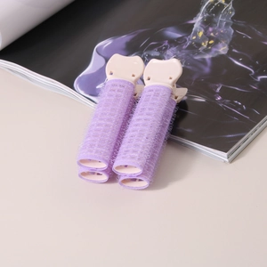 Dettaglio di due fermagli rosa e viola per dare volume ai capelli su una rivista