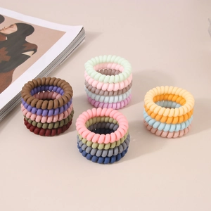 Gros plan d'élastiques à cheveux spirale mats aux couleurs pastel et texture douce