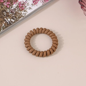 Gros plan d'un chouchou spirale marron mat avec un design de cordon de téléphone flexible