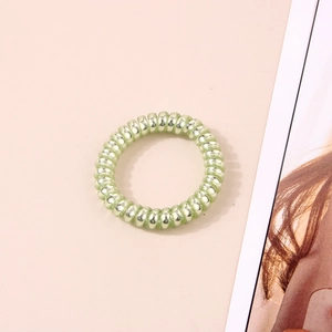 Détail d'un élastique spirale vert clair haute élasticité avec finition brillante sur rose