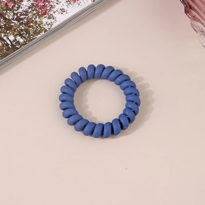 Gros plan d'un chouchou spirale bleu foncé mat sur un fond rose au style minimaliste