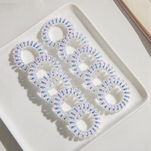 Lot de 10 élastiques à cheveux spirales holographiques sur un plateau en céramique