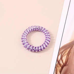Détail de l'élastique à cheveux spirale violet brillant au design de cordon de téléphone