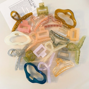 Assortiment de grandes pinces à cheveux jelly couleurs Morandi sur fond minimaliste