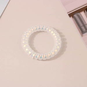 Gros plan sur un chouchou spirale mat irisé avec finition laser sirène sur fond beige