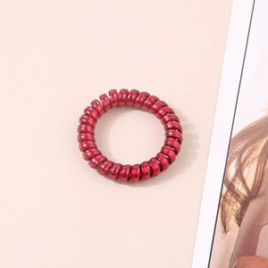 Détail macro d'un élastique spirale rouge brillant à haute élasticité pour cheveux