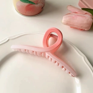 Elegant gradient pink cherry blossom hair claw clip with matte finish on decorative ceramic tray