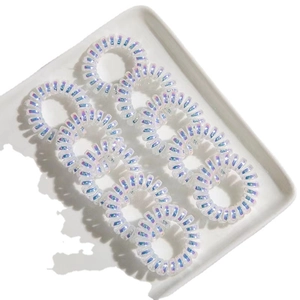 Lot de 9 élastiques à cheveux spirales irisés avec effet laser sur un plateau blanc
