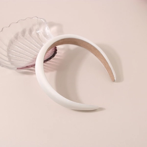 Détail du serre-tête rembourré en satin blanc avec doublure antidérapante et design épais
